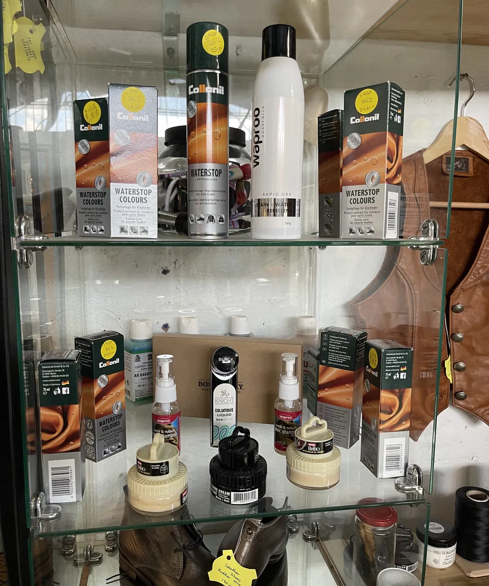 A glass cabinet of Collonil waterproofing sprays, creams and polishes in the shop
