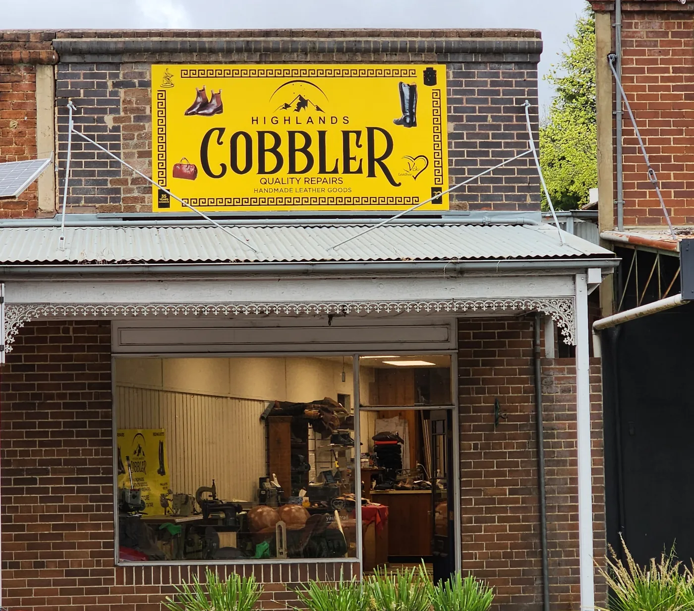 The Highlands Cobbler shopfront at 426 Argyle Street, Moss Vale, with its big yellow sign above the verandah